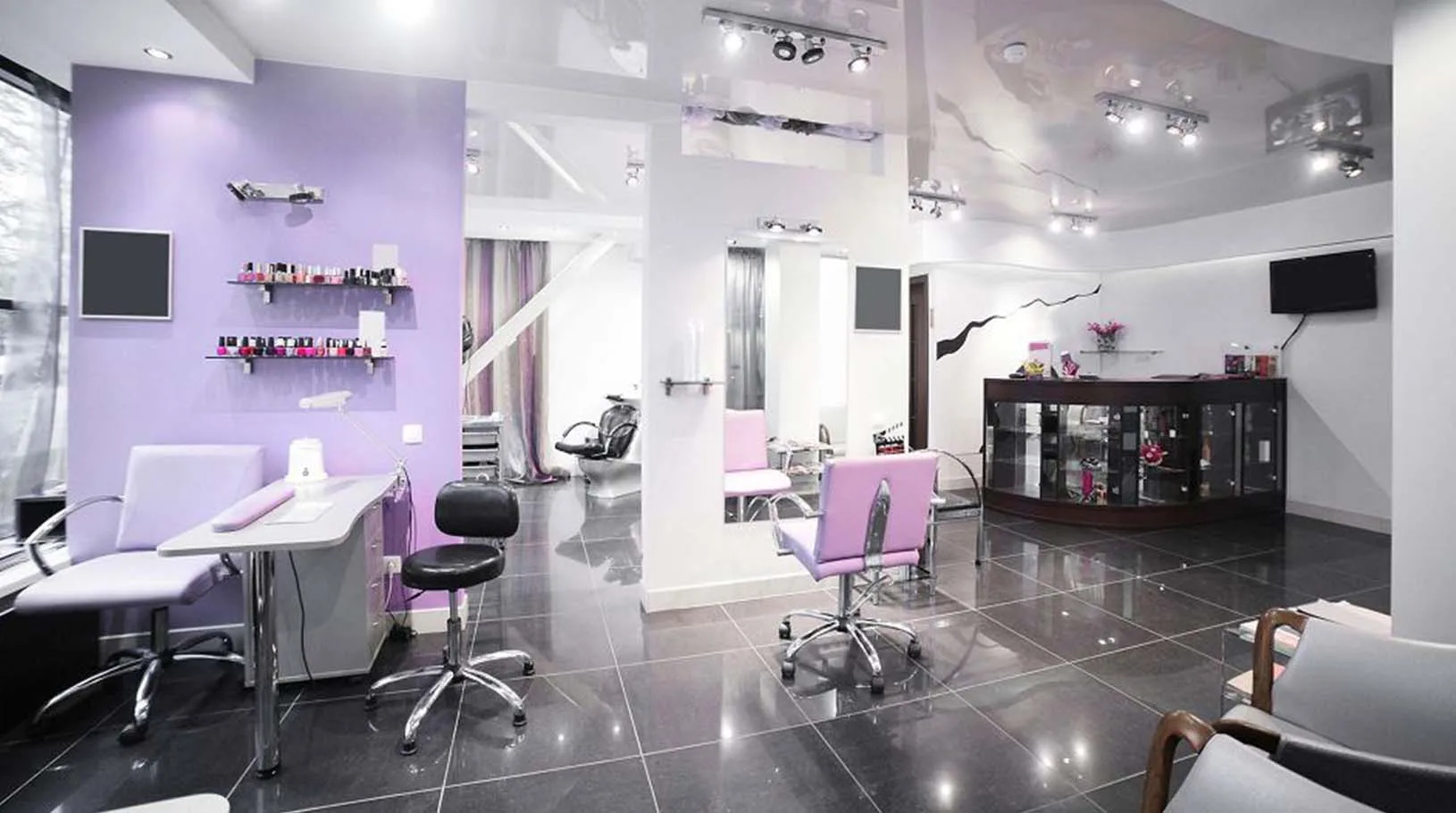 Salón de belleza reformado con pared lila y suelo porcelánico negro